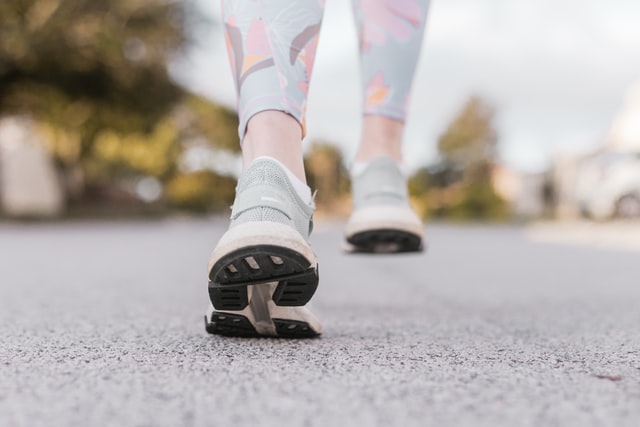 person in light blue running room and pink blue and white leggings on a walking trail